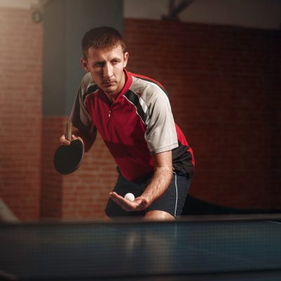 Man with racket in action, playing table tennis